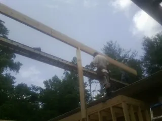 Carpenter setting a ridge beam over a new addition frame — Ice Dam Removal by Roofing Brothers in Durham
