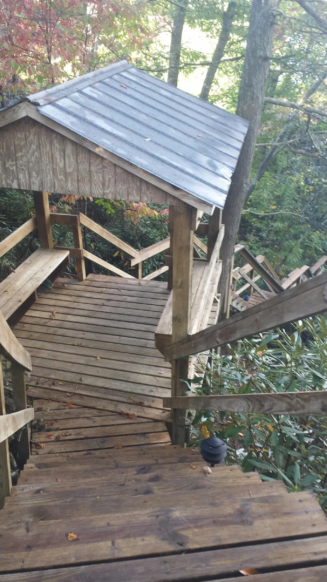 Metal roofed shelter over wooden steps on a wooded walkway — Skylight Repair & Installation work by our crew in Durham