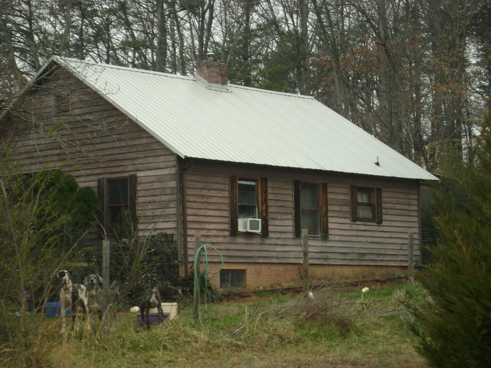 White metal roof on an old wood sided farmhouse, from a Asphalt Shingle Roof Repair job in Durham